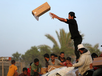 Palestinians are climbing onto trucks to grab aid that is being delivered into Gaza through a U.S.-built pier, amid the ongoing conflict bet...