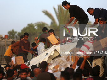 Palestinians are climbing onto trucks to grab aid that is being delivered into Gaza through a U.S.-built pier, amid the ongoing conflict bet...