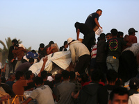 Palestinians are climbing onto trucks to grab aid that is being delivered into Gaza through a U.S.-built pier, amid the ongoing conflict bet...