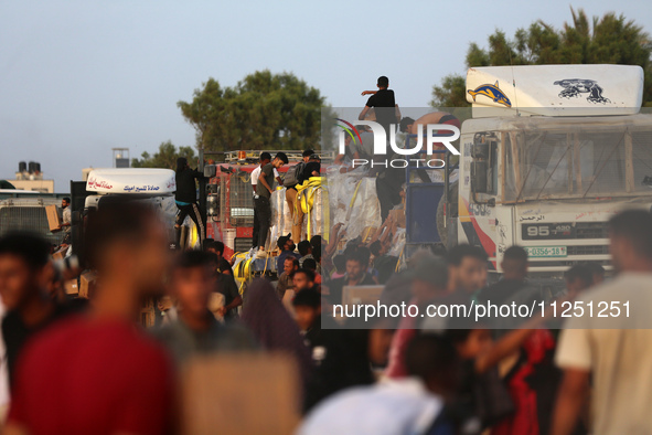 Palestinians are climbing onto trucks to grab aid that is being delivered into Gaza through a U.S.-built pier, amid the ongoing conflict bet...