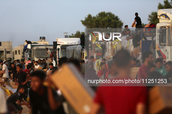 Palestinians are climbing onto trucks to grab aid that is being delivered into Gaza through a U.S.-built pier, amid the ongoing conflict bet...