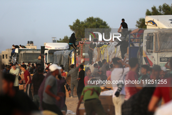 Palestinians are climbing onto trucks to grab aid that is being delivered into Gaza through a U.S.-built pier, amid the ongoing conflict bet...