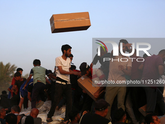 Palestinians are climbing onto trucks to grab aid that is being delivered into Gaza through a U.S.-built pier, amid the ongoing conflict bet...