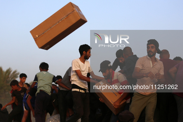 Palestinians are climbing onto trucks to grab aid that is being delivered into Gaza through a U.S.-built pier, amid the ongoing conflict bet...