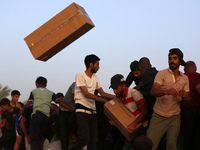 Palestinians are climbing onto trucks to grab aid that is being delivered into Gaza through a U.S.-built pier, amid the ongoing conflict bet...