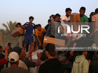 Palestinians are climbing onto trucks to grab aid that is being delivered into Gaza through a U.S.-built pier, amid the ongoing conflict bet...