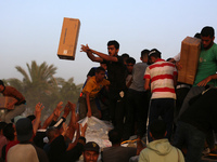 Palestinians are climbing onto trucks to grab aid that is being delivered into Gaza through a U.S.-built pier, amid the ongoing conflict bet...