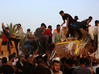 Palestinians are climbing onto trucks to grab aid that is being delivered into Gaza through a U.S.-built pier, amid the ongoing conflict bet...