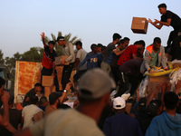 Palestinians are climbing onto trucks to grab aid that is being delivered into Gaza through a U.S.-built pier, amid the ongoing conflict bet...