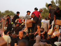 Palestinians are climbing onto trucks to grab aid that is being delivered into Gaza through a U.S.-built pier, amid the ongoing conflict bet...