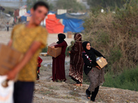 Palestinians are carrying boxes of aid that are being delivered into Gaza through a U.S.-built pier, amid the ongoing conflict between Israe...