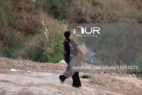 Palestinians are carrying boxes of aid that are being delivered into Gaza through a U.S.-built pier, amid the ongoing conflict between Israe...