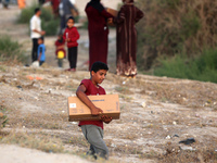 Palestinians are carrying boxes of aid that are being delivered into Gaza through a U.S.-built pier, amid the ongoing conflict between Israe...