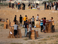 Palestinians are carrying boxes of aid that are being delivered into Gaza through a U.S.-built pier, amid the ongoing conflict between Israe...