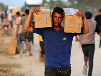 Palestinians are carrying boxes of aid that are being delivered into Gaza through a U.S.-built pier, amid the ongoing conflict between Israe...