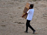 Palestinians are carrying boxes of aid that are being delivered into Gaza through a U.S.-built pier, amid the ongoing conflict between Israe...