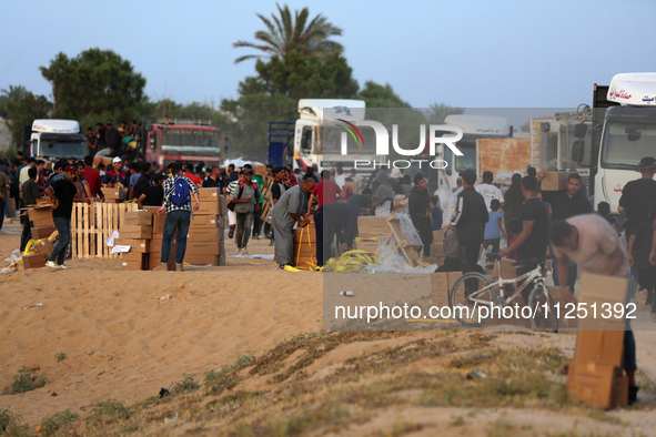 Palestinians are carrying boxes of aid that are being delivered into Gaza through a U.S.-built pier, amid the ongoing conflict between Israe...