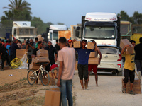 Palestinians are carrying boxes of aid that are being delivered into Gaza through a U.S.-built pier, amid the ongoing conflict between Israe...