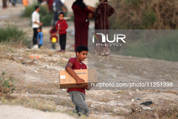 Palestinians are carrying boxes of aid that are being delivered into Gaza through a U.S.-built pier, amid the ongoing conflict between Israe...