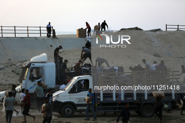 Palestinians are carrying boxes of aid that are being delivered into Gaza through a U.S.-built pier, amid the ongoing conflict between Israe...