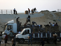 Palestinians are carrying boxes of aid that are being delivered into Gaza through a U.S.-built pier, amid the ongoing conflict between Israe...