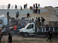 Palestinians are climbing onto trucks to grab aid that is being delivered into Gaza through a U.S.-built pier, amid the ongoing conflict bet...