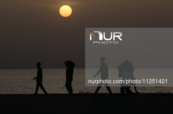 Palestinians are carrying boxes of aid that are being delivered into Gaza through a U.S.-built pier, amid the ongoing conflict between Israe...