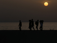 Palestinians are carrying boxes of aid that are being delivered into Gaza through a U.S.-built pier, amid the ongoing conflict between Israe...