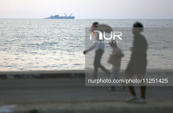 Palestinians are carrying boxes of aid that are being delivered into Gaza through a U.S.-built pier, amid the ongoing conflict between Israe...