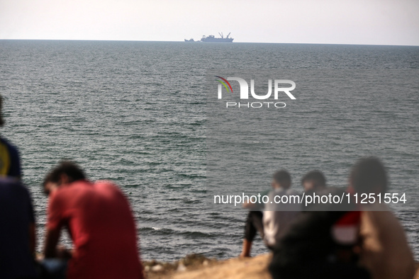 Palestinians are grabbing aid from a truck that is being delivered into Gaza through a U.S.-built pier, amid the ongoing conflict between Is...