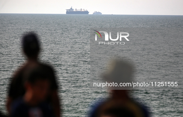 Palestinians are grabbing aid from a truck that is being delivered into Gaza through a U.S.-built pier, amid the ongoing conflict between Is...