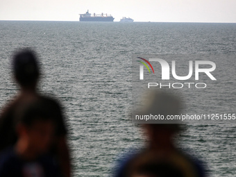 Palestinians are grabbing aid from a truck that is being delivered into Gaza through a U.S.-built pier, amid the ongoing conflict between Is...