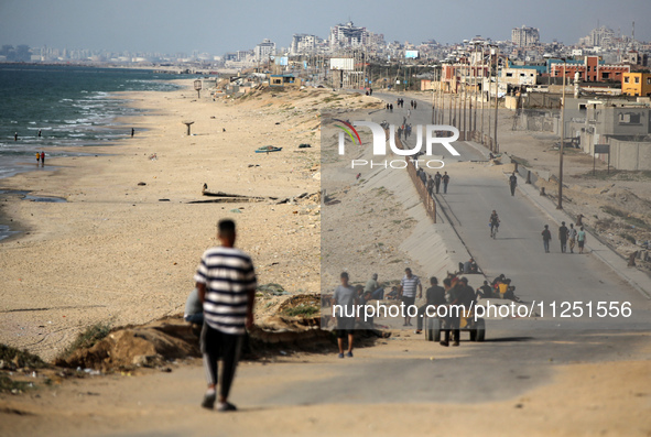 Palestinians are standing on a beach, as a U.S.-built pier is pictured in the background, as seen from central Gaza Strip, on May 18, 2024 