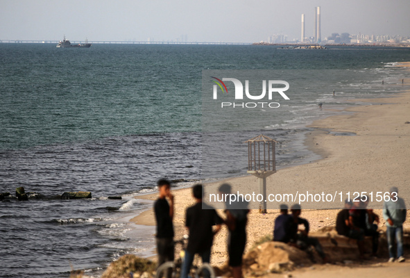 Palestinians are grabbing aid from a truck that is being delivered into Gaza through a U.S.-built pier, amid the ongoing conflict between Is...