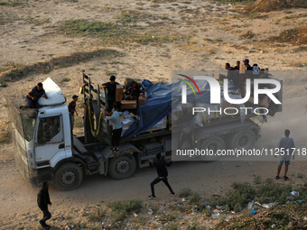 Palestinians are grabbing aid from a truck that is being delivered into Gaza through a U.S.-built pier, amid the ongoing conflict between Is...