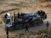 Palestinians are grabbing aid from a truck that is being delivered into Gaza through a U.S.-built pier, amid the ongoing conflict between Is...