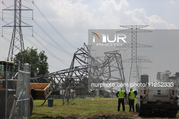 Electrical workers are looking toward a mangled transmission tower at the intersection of Gardendale Dr. and Antoine Dr. as crews throughout...