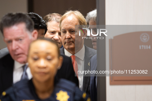 Texas Attorney General Ken Paxton is emerging from a back door in the Harris County Criminal Justice Center and is approaching the 185th Cri...