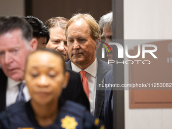 Texas Attorney General Ken Paxton is emerging from a back door in the Harris County Criminal Justice Center and is approaching the 185th Cri...