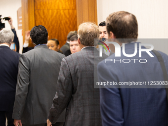 Texas Attorney General Ken Paxton is walking with his entourage toward the courtroom at the Harris County Criminal Justice Center in Houston...