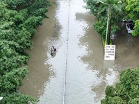 A citizen is riding in 50 cm of water after heavy rain in Nanning, China, on May 19, 2024. (