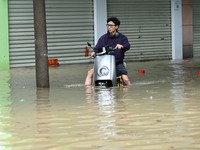 A citizen is riding in 50 cm of water after heavy rain in Nanning, China, on May 19, 2024. (