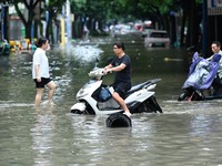 Citizens are riding in 50 cm of water after heavy rain in Nanning, China, on May 19, 2024. (