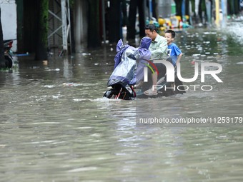 Citizens are riding in 50 cm of water after heavy rain in Nanning, China, on May 19, 2024. (