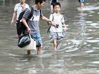 Citizens are walking on a flooded road after heavy rain in Nanning, China, on May 19, 2024. (