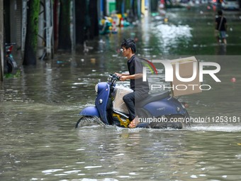 A citizen is riding in 50 cm of water after heavy rain in Nanning, China, on May 19, 2024. (