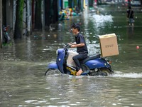 A citizen is riding in 50 cm of water after heavy rain in Nanning, China, on May 19, 2024. (