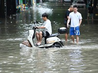 A citizen is riding in 50 cm of water after heavy rain in Nanning, China, on May 19, 2024. (