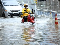 A citizen is riding in 50 cm of water after heavy rain in Nanning, China, on May 19, 2024. (