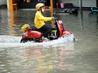 A citizen is riding in 50 cm of water after heavy rain in Nanning, China, on May 19, 2024. (